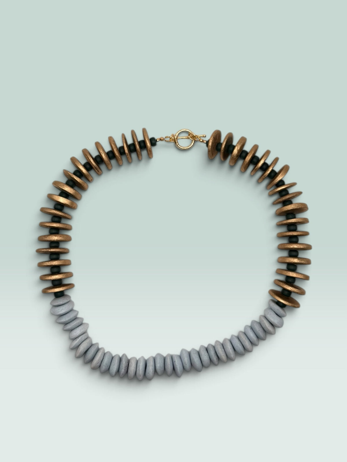 The Salty Bead Co handcrafted statement necklace featuring metallic gold and slate-grey flattened disc beads with a toggle