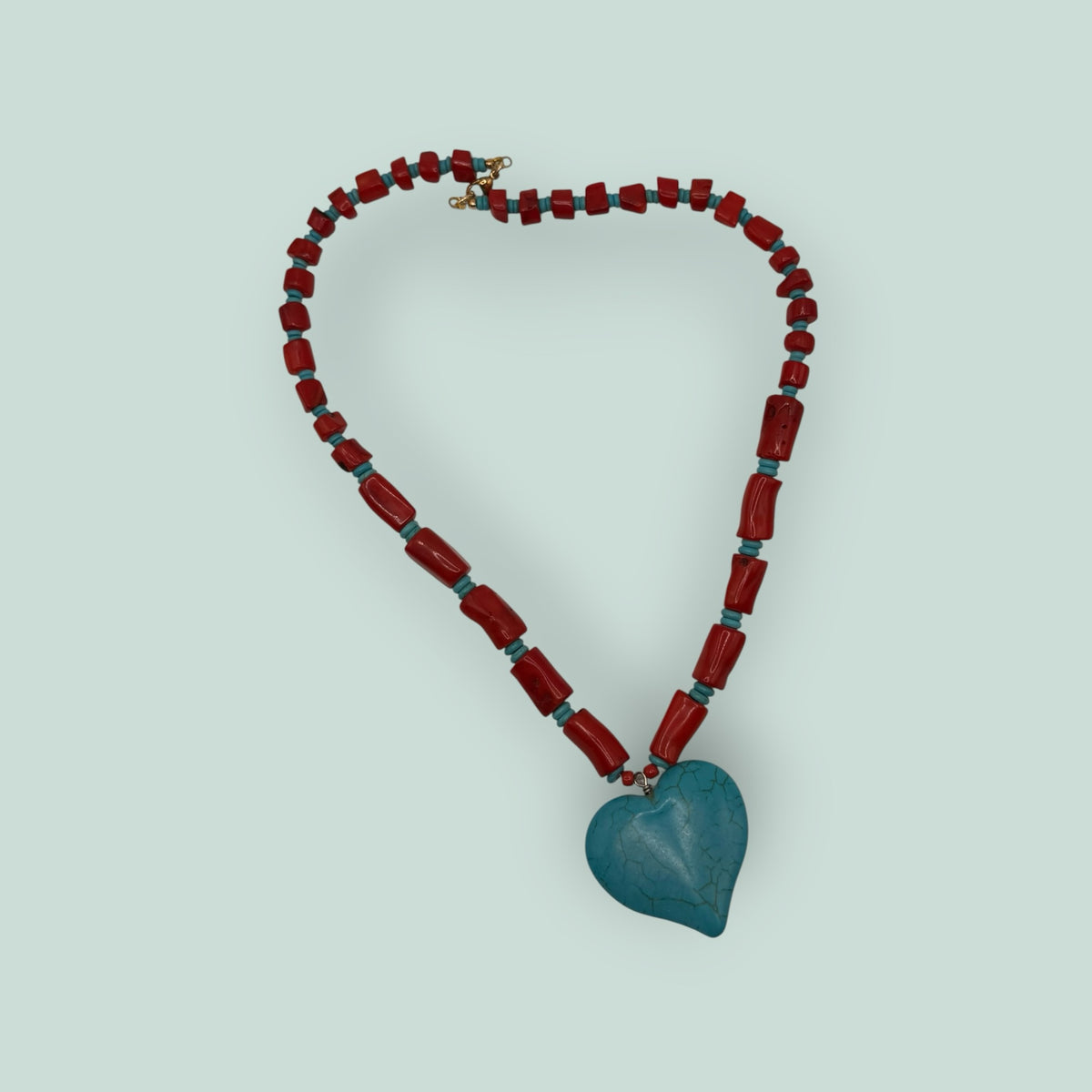 The Salty Bead Co artisan heart pendant necklace with red coral-style beads and a textured turquoise heart charm.