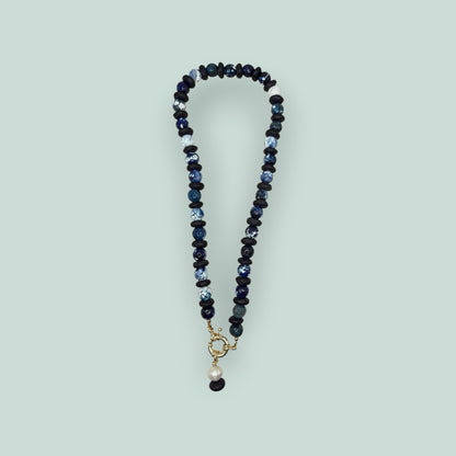 The Salty Bead Co artisan necklace with navy and marbled blue agate beads, matte black spacers, and a gold-tone clasp.
