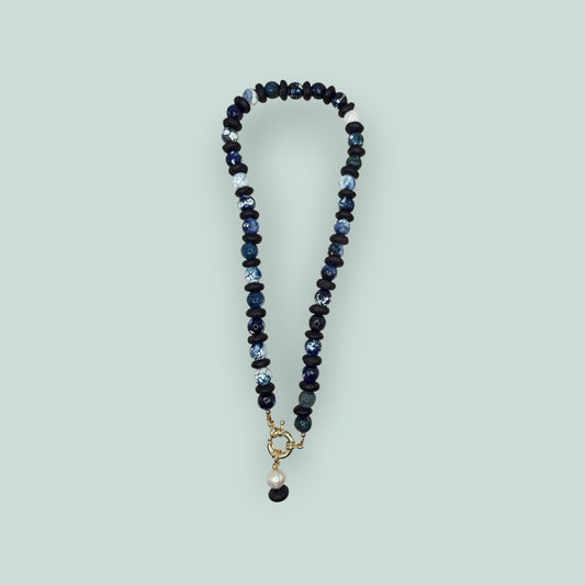 The Salty Bead Co artisan necklace with navy and marbled blue agate beads, matte black spacers, and a gold-tone clasp.