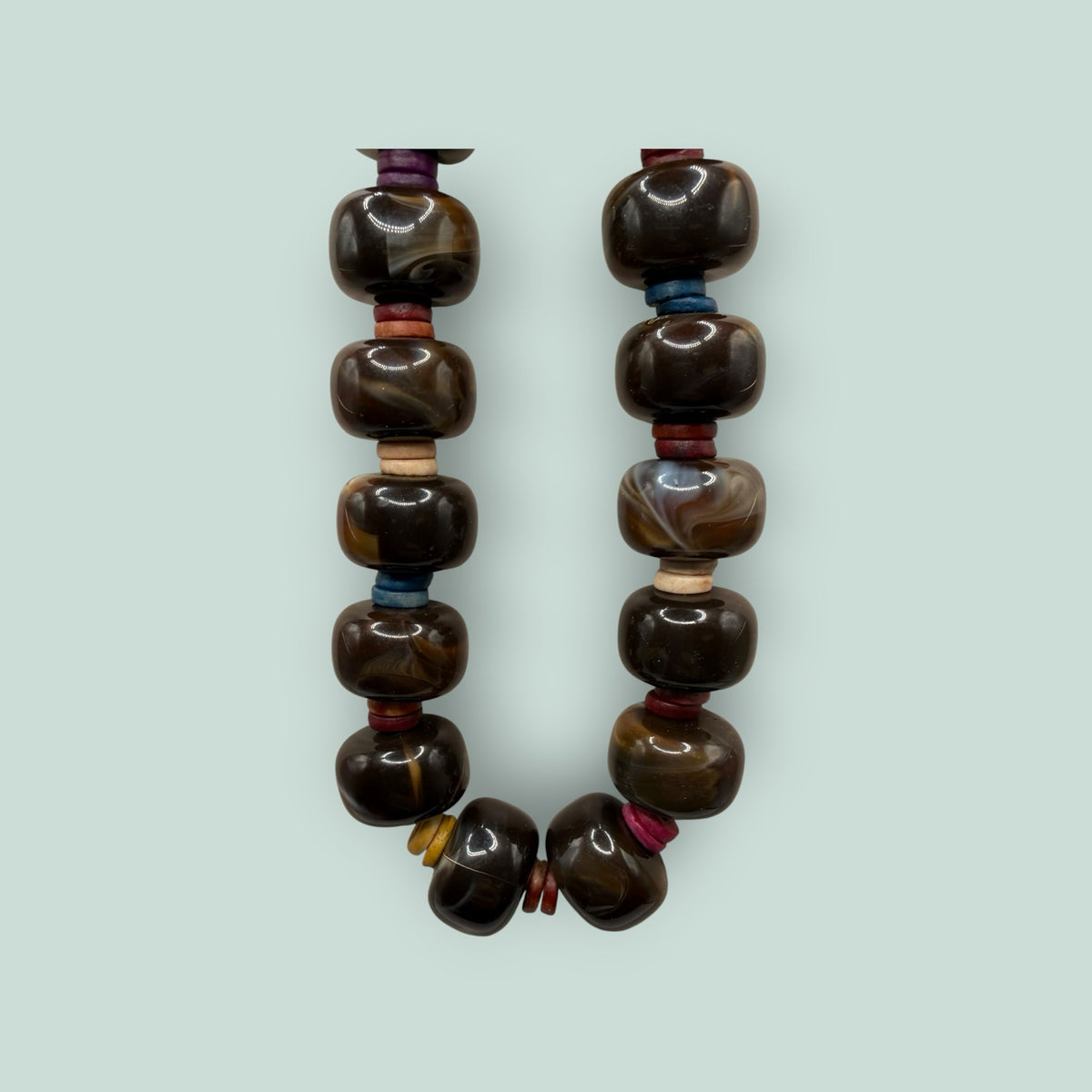 The Salty Bead Co handcrafted statement necklace featuring polished dark brown agate beads with colorful spacers.