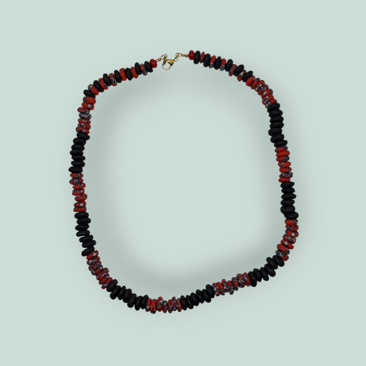 The Salty Bead Co handcrafted necklace with matte black disc beads and patterned red and blue glass beads