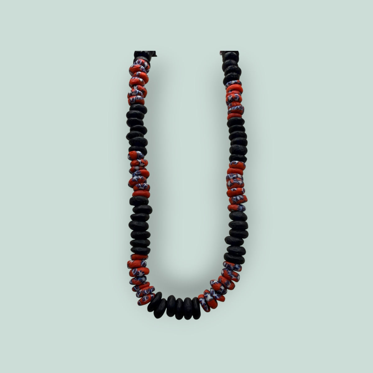 The Salty Bead Co handcrafted necklace with matte black disc beads and patterned red and blue glass accent beads