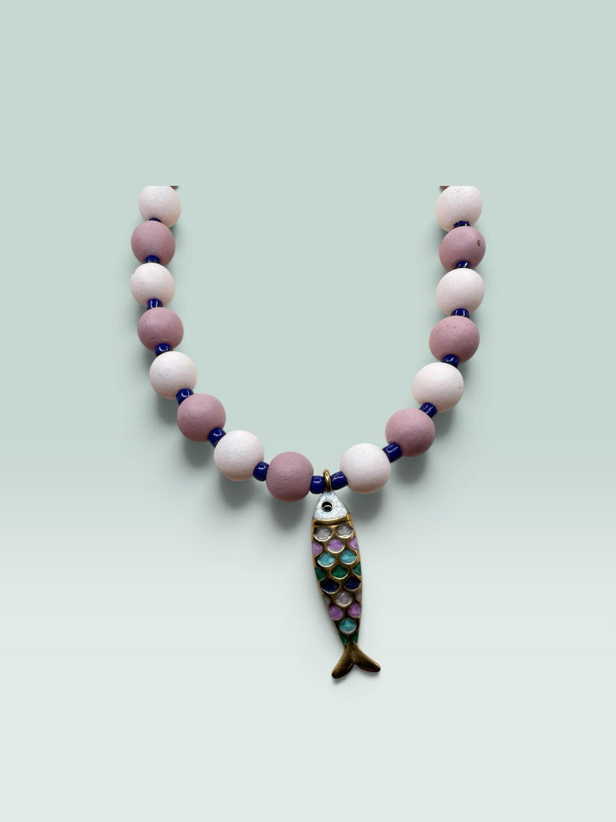 The Salty Bead Co handcrafted necklace with mauve and pink matte beads, blue spacers, and a colorful enamel fish charm