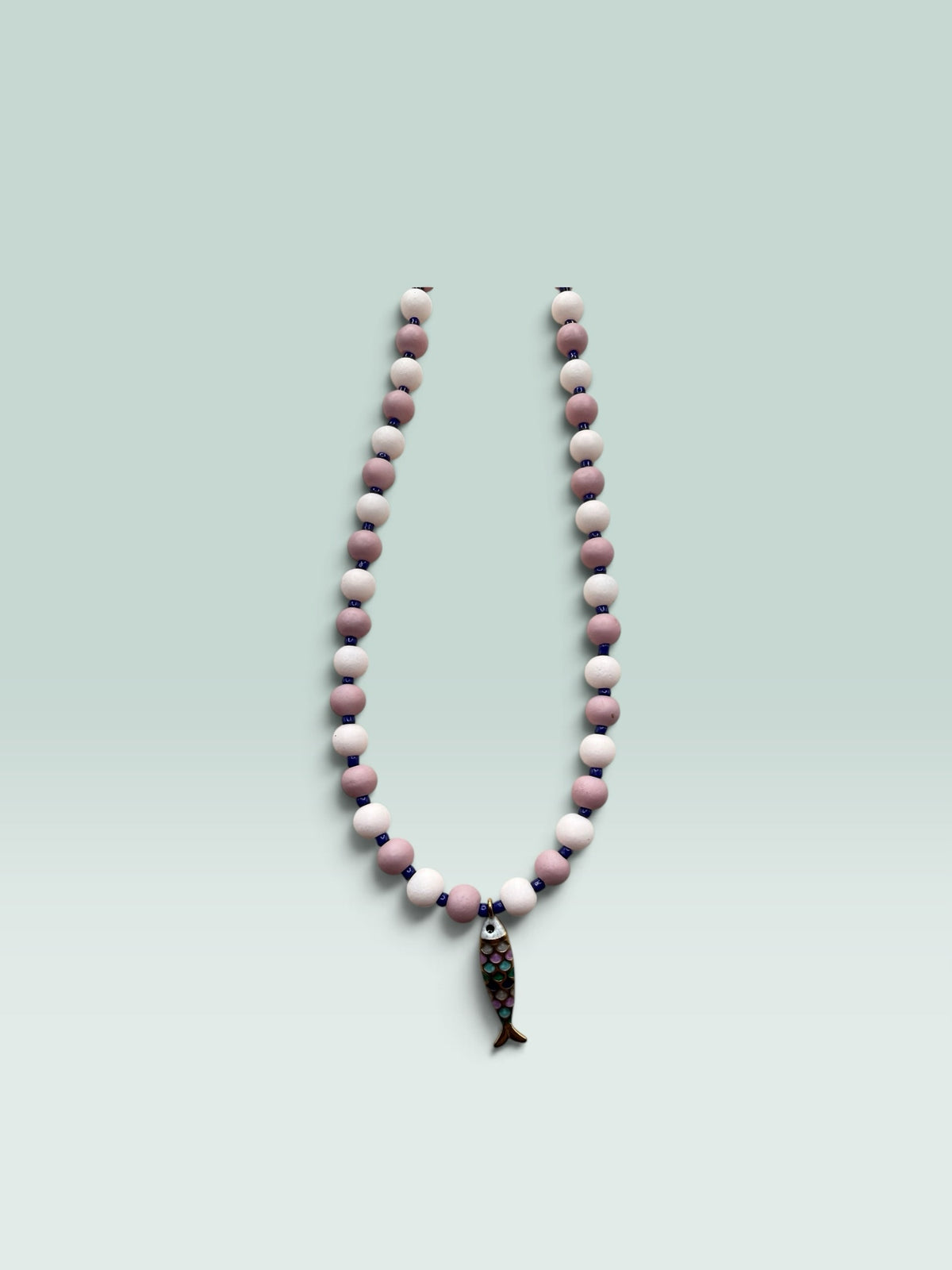 The Salty Bead Co handcrafted necklace with mauve and pink matte beads, blue spacers, and a colorful enamel fish charm.