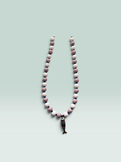 The Salty Bead Co handcrafted necklace with mauve and pink matte beads, blue spacers, and a colorful enamel fish charm.