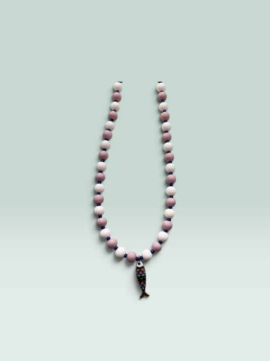 The Salty Bead Co handcrafted necklace with mauve and pink matte beads, blue spacers, and a colorful enamel fish charm.