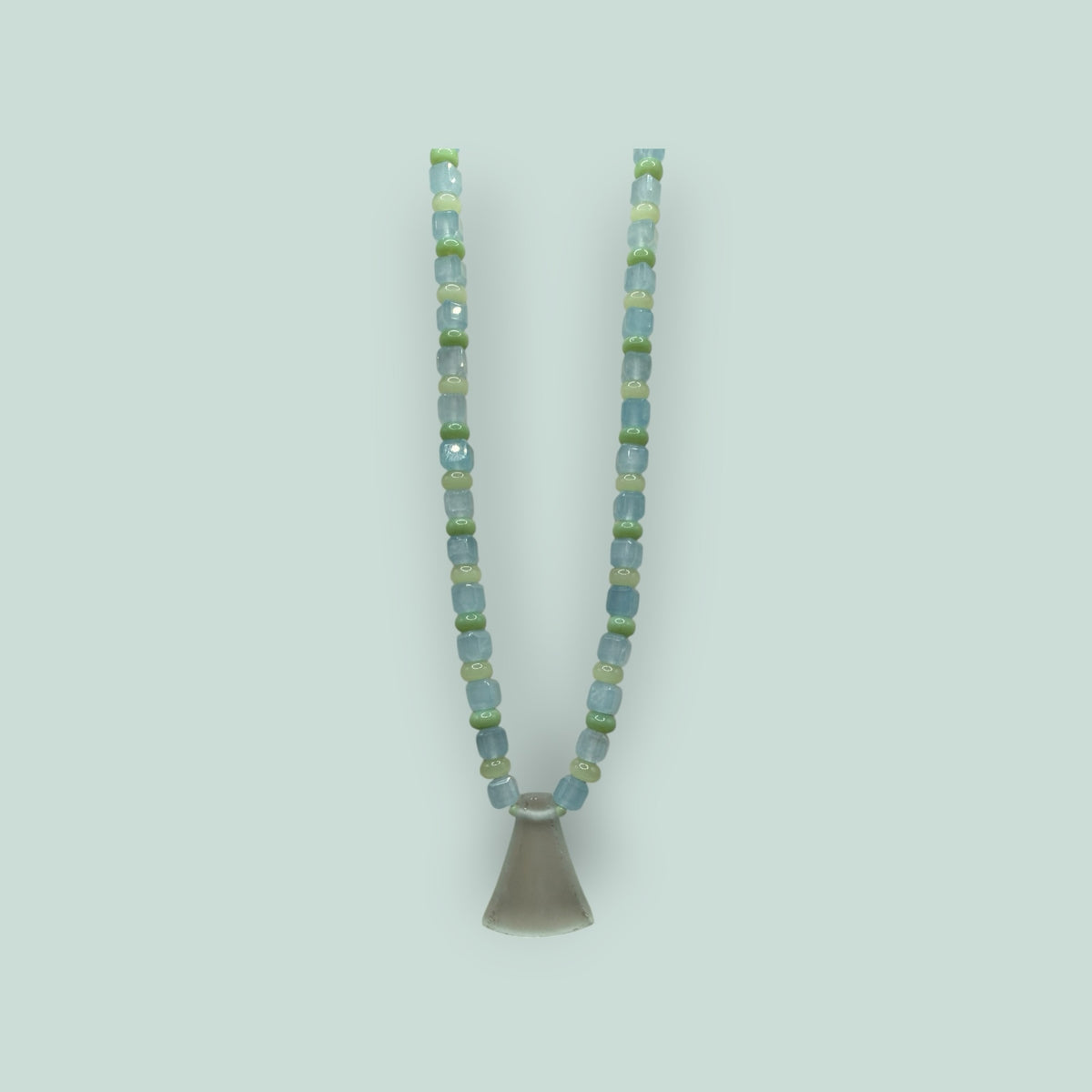The Salty Bead Co handcrafted necklace with light blue and sage green glass beads and a frosted flared glass pendant.