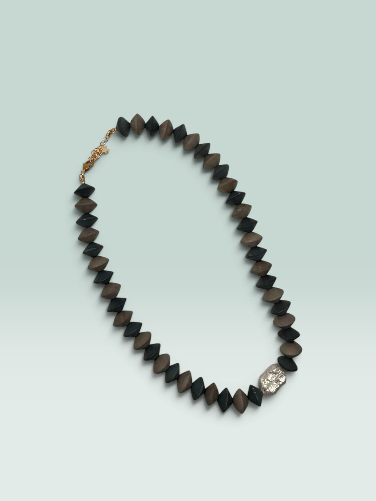 The Salty Bead Co handcrafted statement necklace with matte black and brown geometric beads and metallic accent.