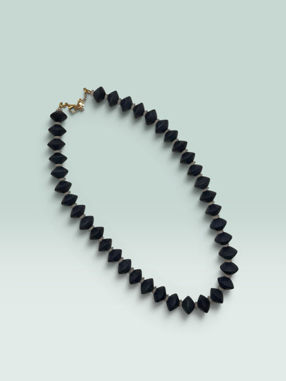 The Salty Bead Co statement necklace featuring matte black geometric bicone beads with neutral spacers