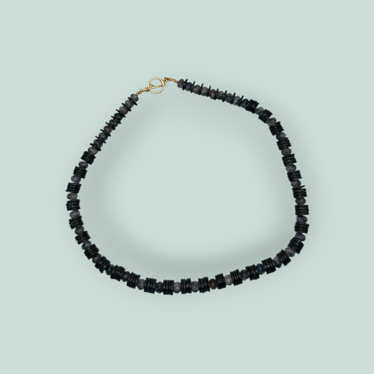 The Salty Bead Co handcrafted necklace with alternating black disc beads and mottled grey stone beads, gold toggle clasp