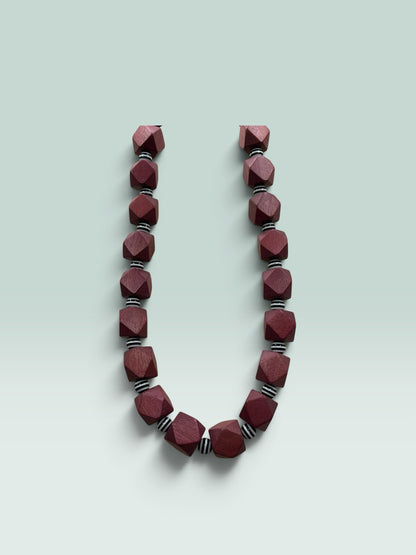 The Salty Bead Co geometric necklace featuring faceted burgundy wooden beads and black and white striped spacers.