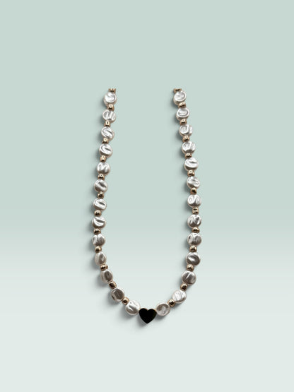 The Salty Bead Co necklace featuring lustrous coin pearls, metallic beads, and a minimalist black heart pendant.