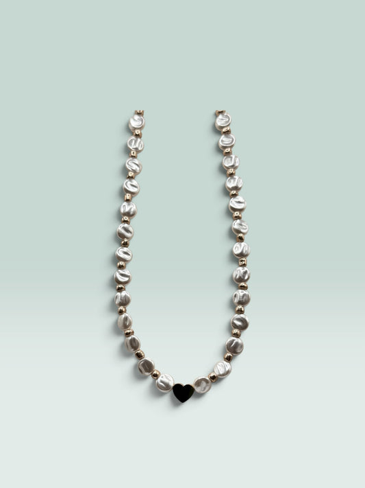 The Salty Bead Co necklace featuring lustrous coin pearls, metallic beads, and a minimalist black heart pendant.