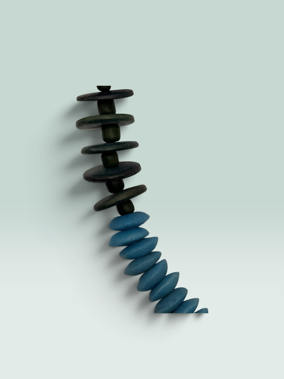 The Salty Bead Co handcrafted statement necklace featuring forest green and sky blue flattened disc beads.