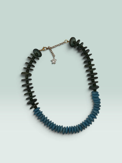 The Salty Bead Co handcrafted statement necklace featuring forest green and sky blue disc beads with a star charm.
