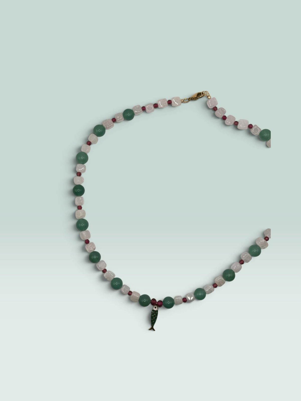 The Salty Bead Co beaded necklace with green aventurine, white quartz, red accents, and a green enamel fish pendant.
