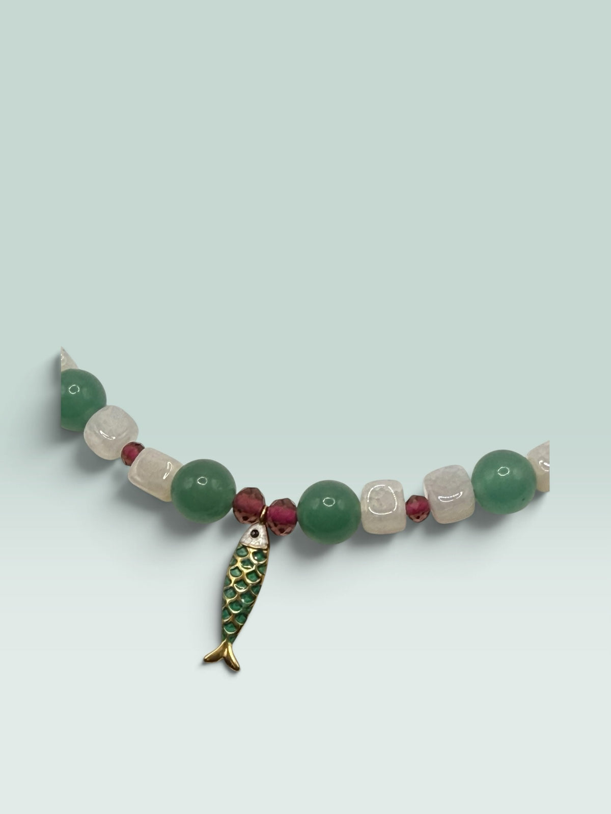 The Salty Bead Co beaded necklace featuring green aventurine, white quartz, red accents, and a green enamel fish charm.
