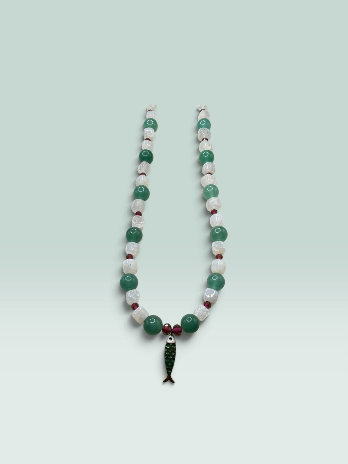 The Salty Bead Co beaded necklace with green aventurine, white quartz, red accents, and a green enamel fish pendant.