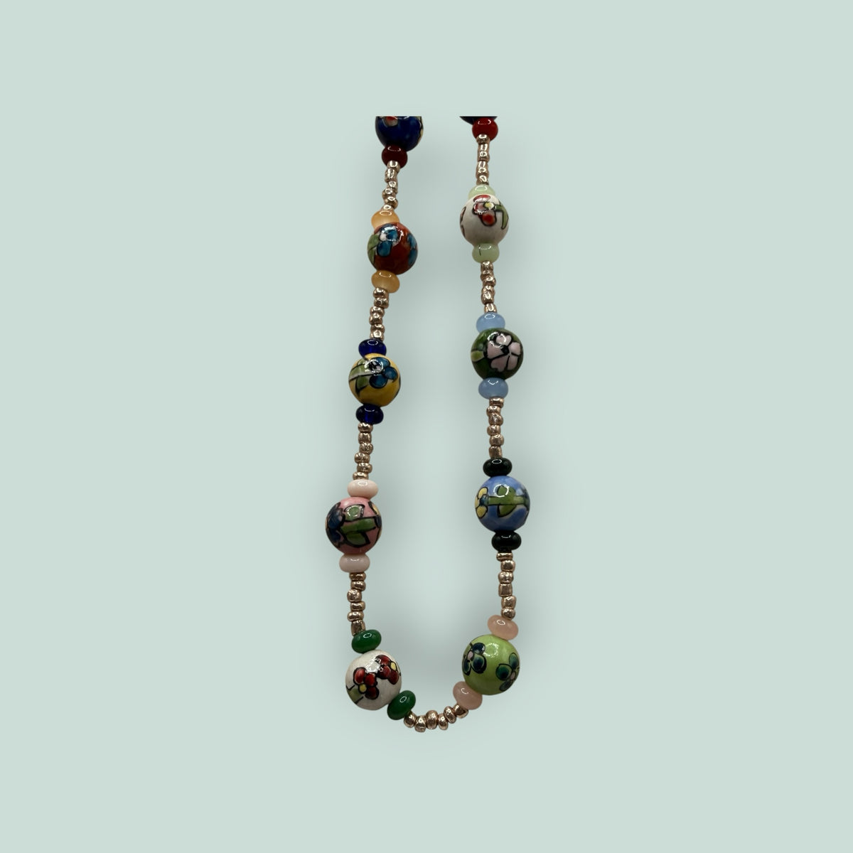 The Salty Bead Co handcrafted necklace featuring vibrant hand-painted ceramic floral beads and metallic spacers.