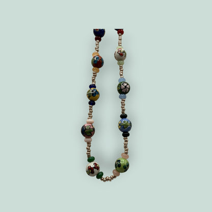 The Salty Bead Co handcrafted necklace featuring vibrant hand-painted ceramic floral beads and metallic spacers.