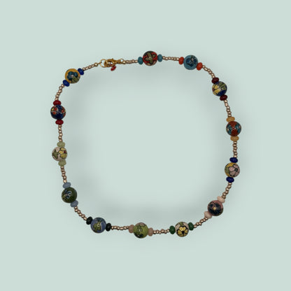 The Salty Bead Co handcrafted necklace featuring multi-colored floral ceramic beads and metallic spacer beads.
