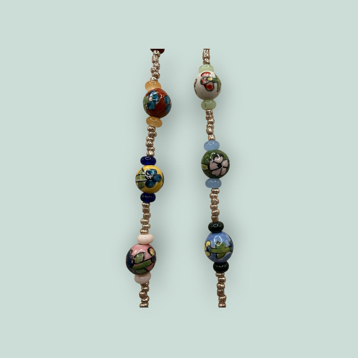 The Salty Bead Co handcrafted necklace with vibrant hand-painted floral ceramic beads and metallic spacer accents.