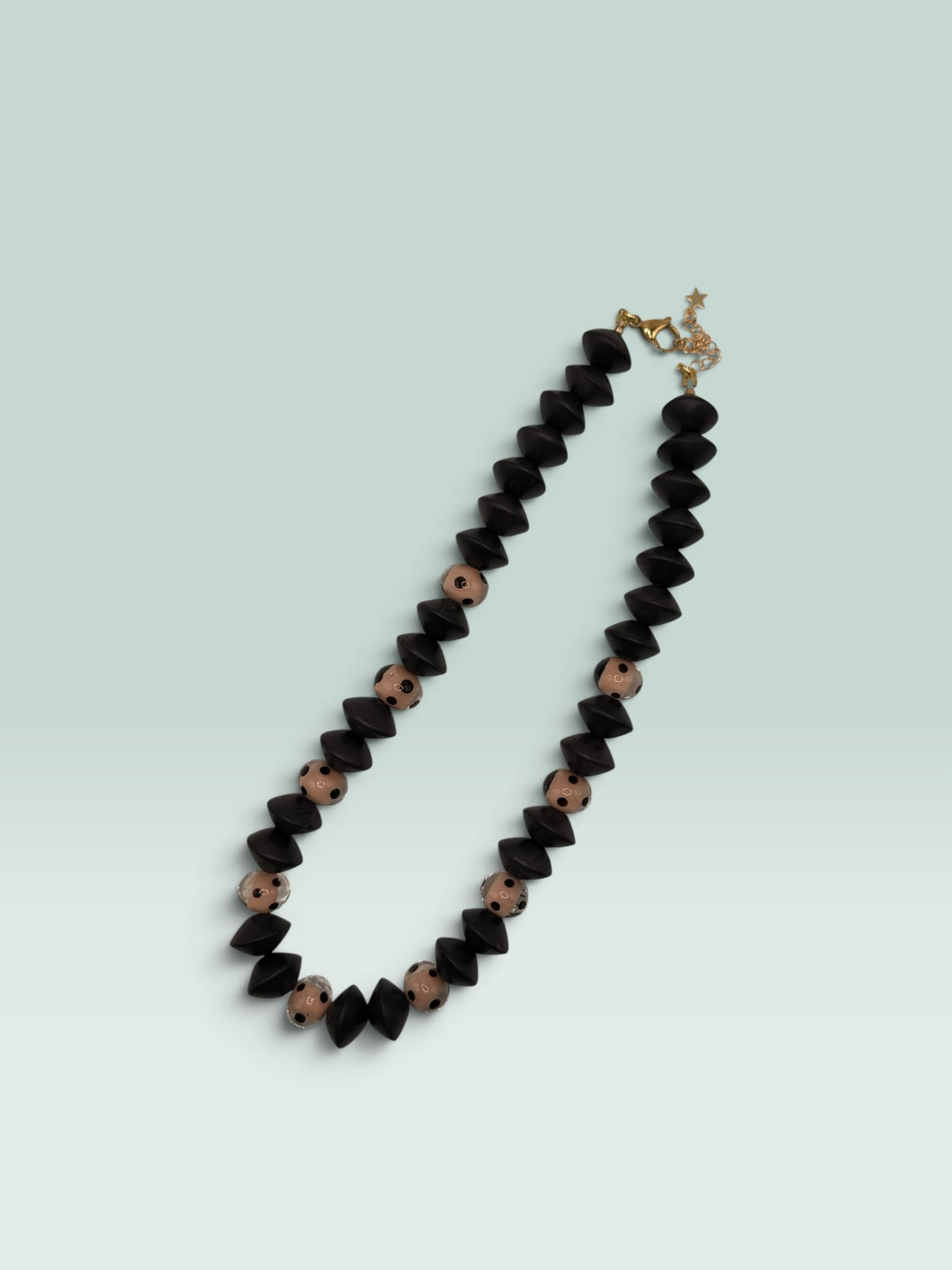 The Salty Bead Co statement necklace featuring matte black geometric beads and blush polka dot beads with gold clasp.