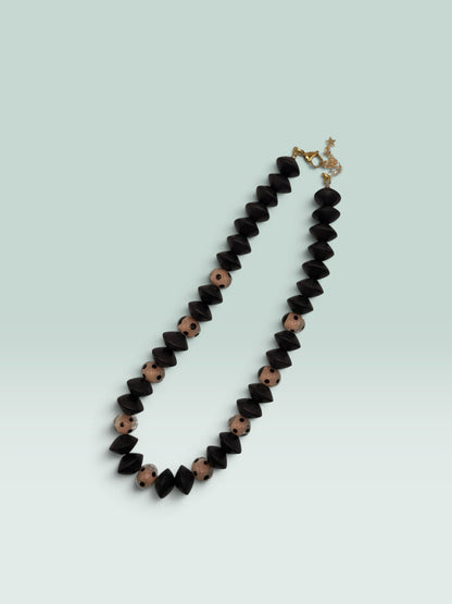 The Salty Bead Co statement necklace featuring matte black geometric beads and blush polka dot beads with gold clasp.