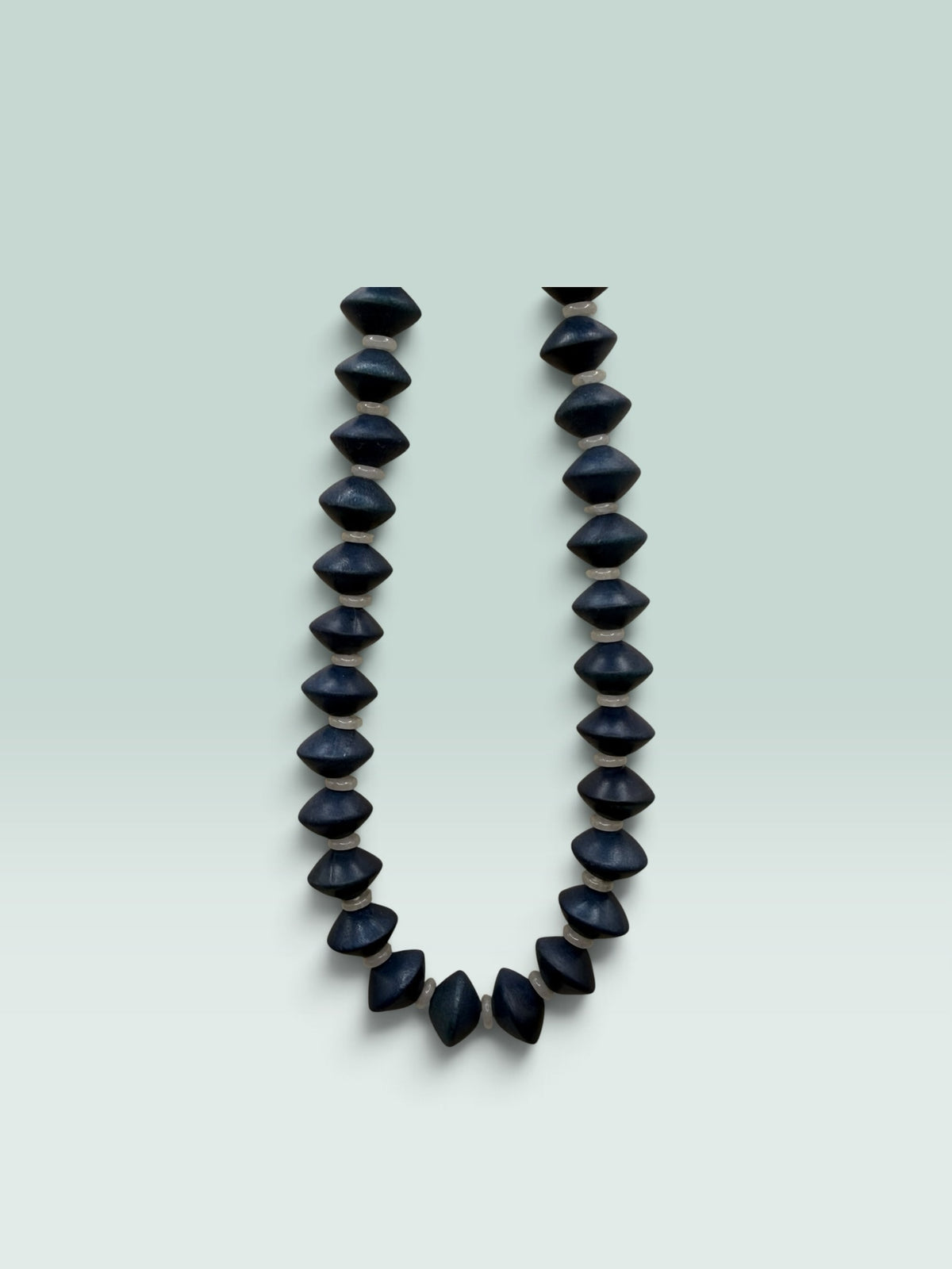 The Salty Bead Co handcrafted statement necklace featuring matte black geometric bicone beads with neutral spacers.