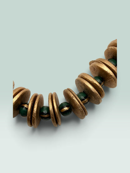 The Salty Bead Co statement necklace featuring textured gold-toned discs and deep forest green beads
