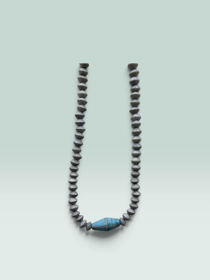 The Salty Bead Co handcrafted necklace featuring grey bicone beads and a central blue bead with metallic detailing.