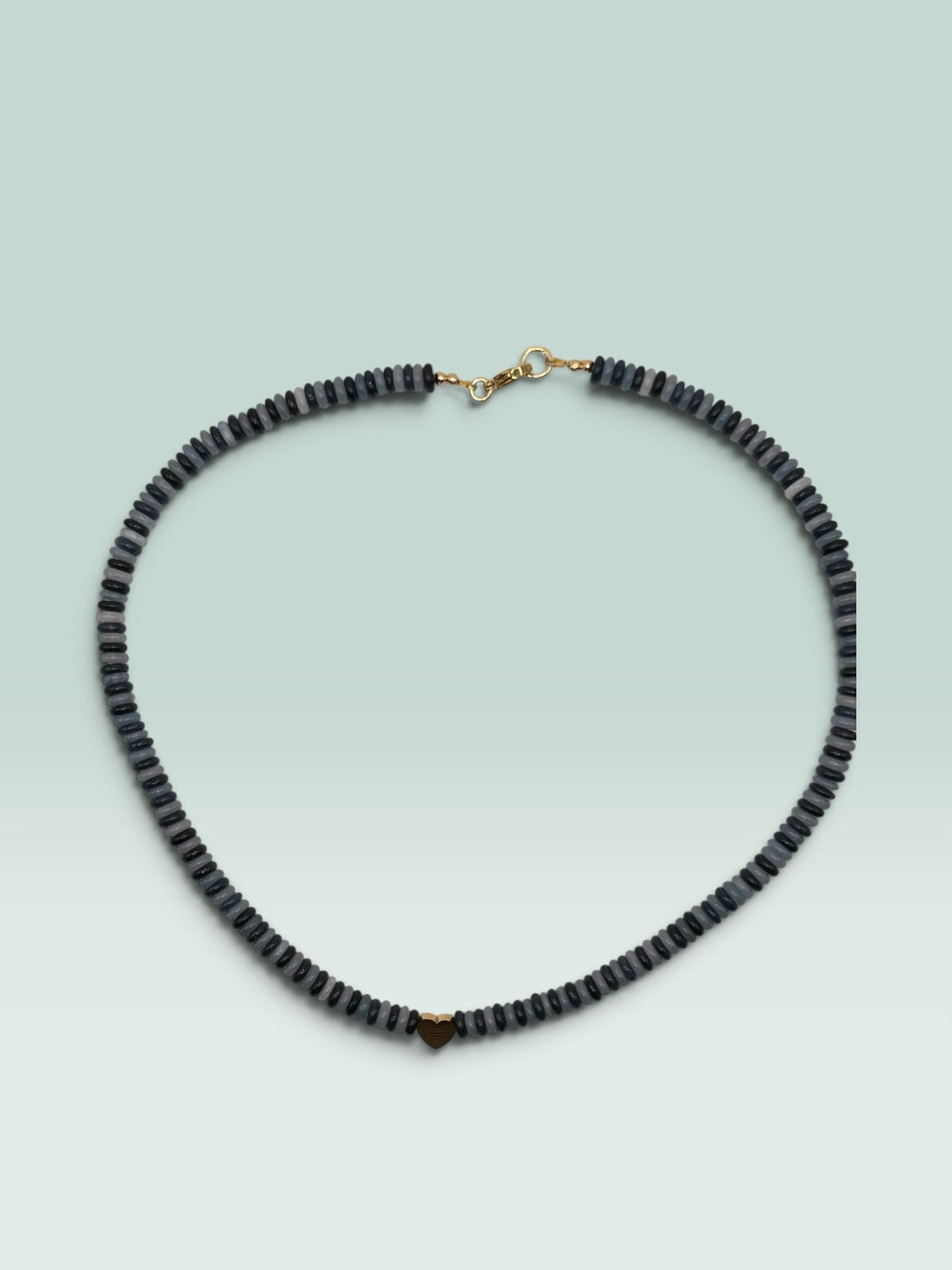 The Salty Bead Co beaded necklace with grey and charcoal disc beads and a small polished gold heart charm