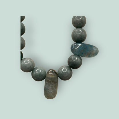 The Salty Bead Co handcrafted statement necklace featuring round grey stone beads and elongated accent stones.