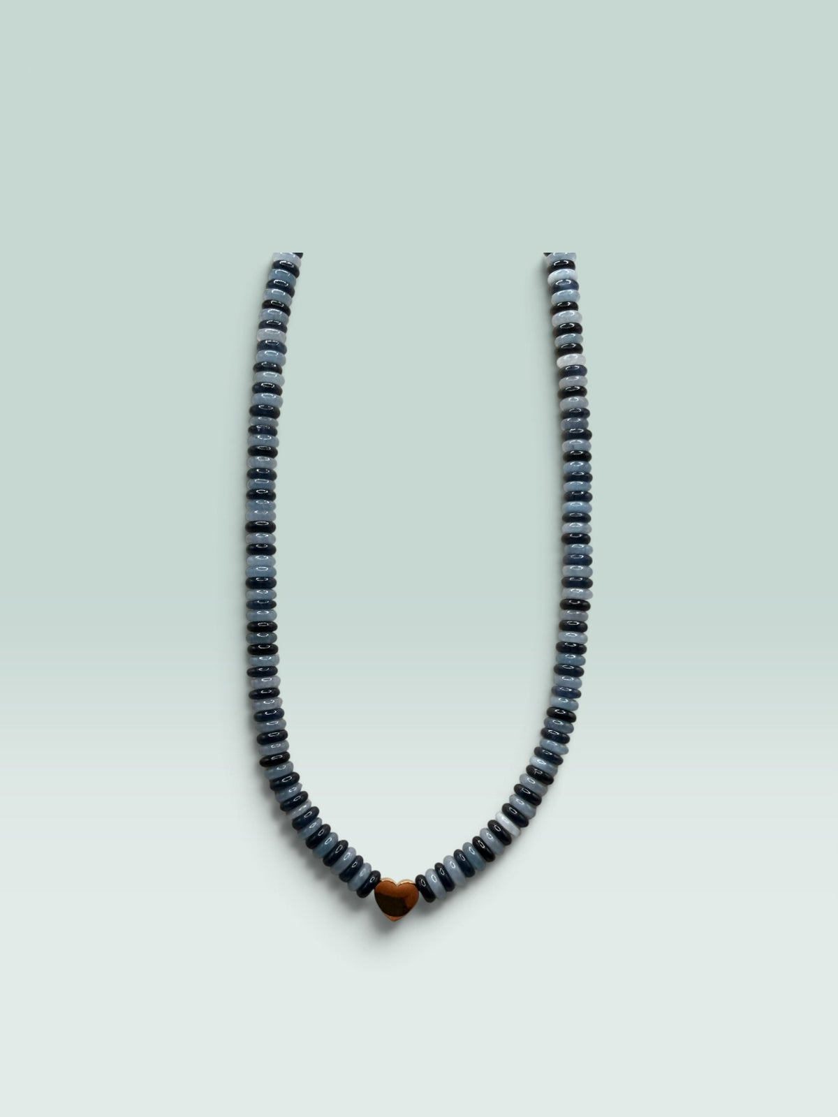 The Salty Bead Co beaded necklace with alternating grey and charcoal disc beads and a polished gold-tone heart charm.