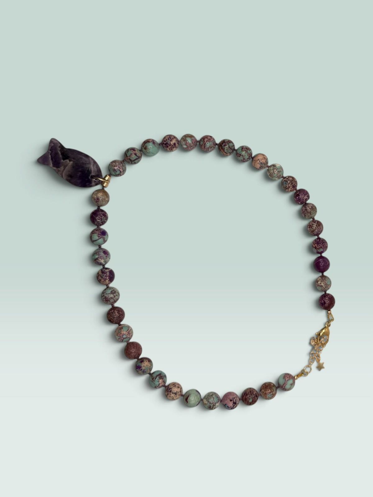 The Salty Bead Co handcrafted necklace with marbled jasper beads in green and purple and a fish-shaped amethyst pendant