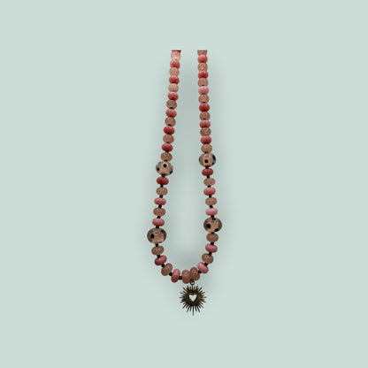 The Salty Bead Co beaded necklace featuring pink and patterned beads with a gold-tone sunburst heart pendant