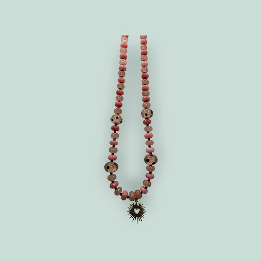 The Salty Bead Co beaded necklace featuring pink and patterned beads with a gold-tone sunburst heart pendant