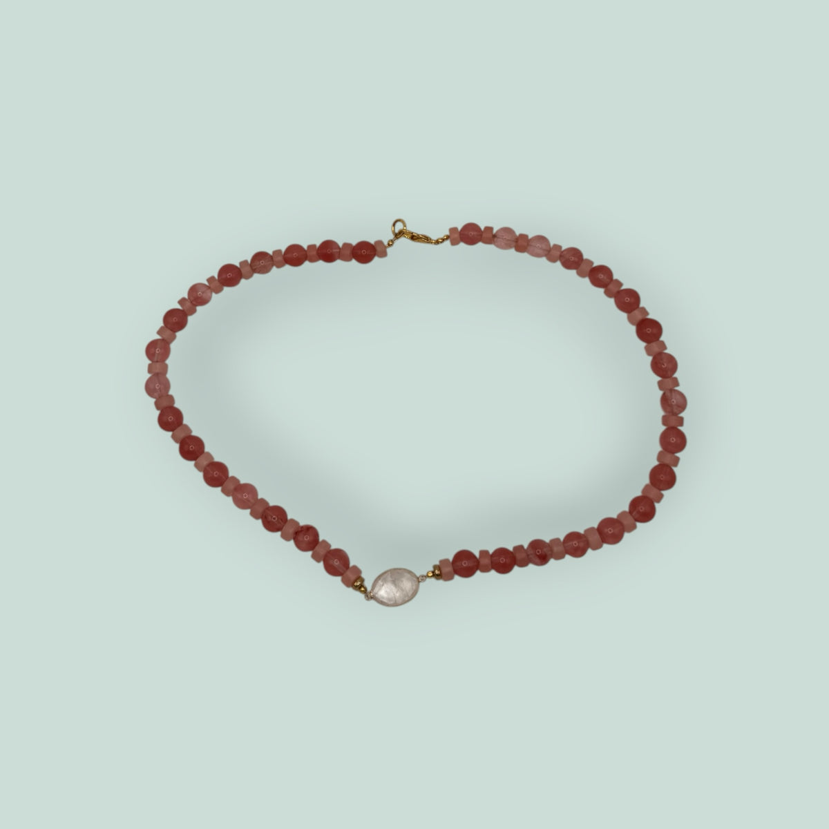 The Salty Bead Co handcrafted necklace with pink and coral beads and a central clear stone pendant