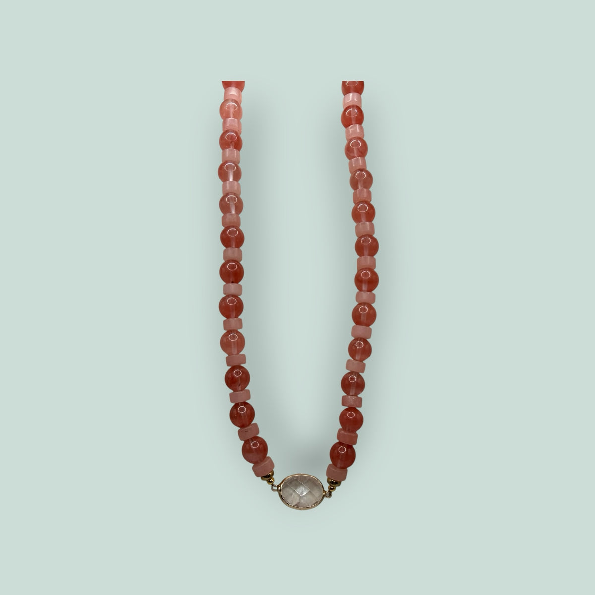 The Salty Bead Co handcrafted necklace with pink and coral beads and a central clear stone pendant