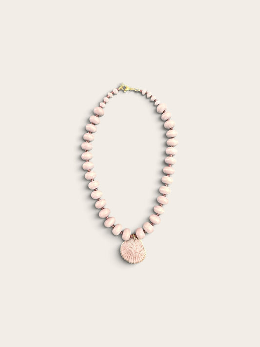 The Salty Bead Co coastal necklace with dusty-pink matte beads and a gold-edged natural seashell pendant.