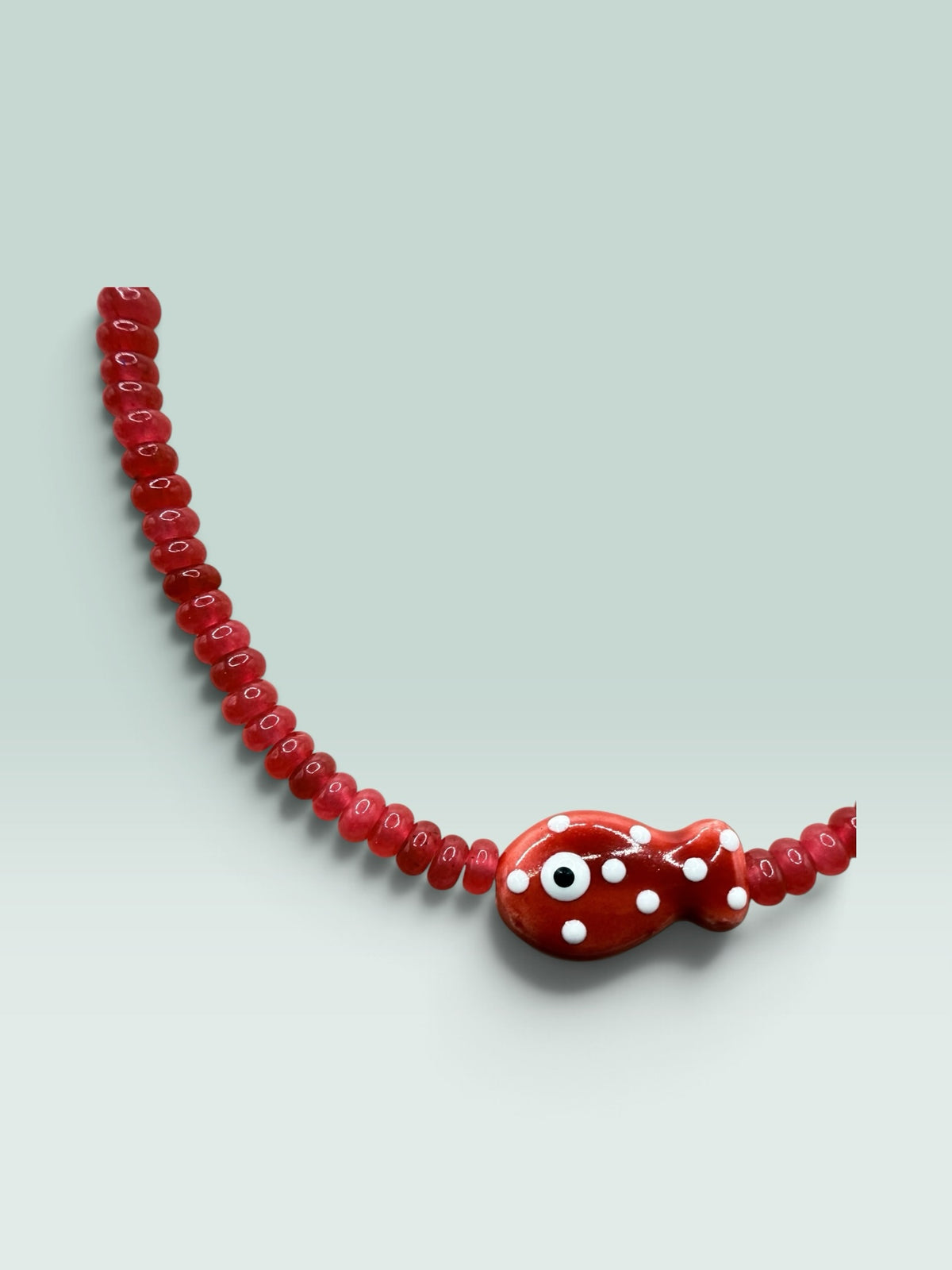 The Salty Bead Co red beaded necklace featuring a whimsical fish pendant with white polka dots and evil eye detail.