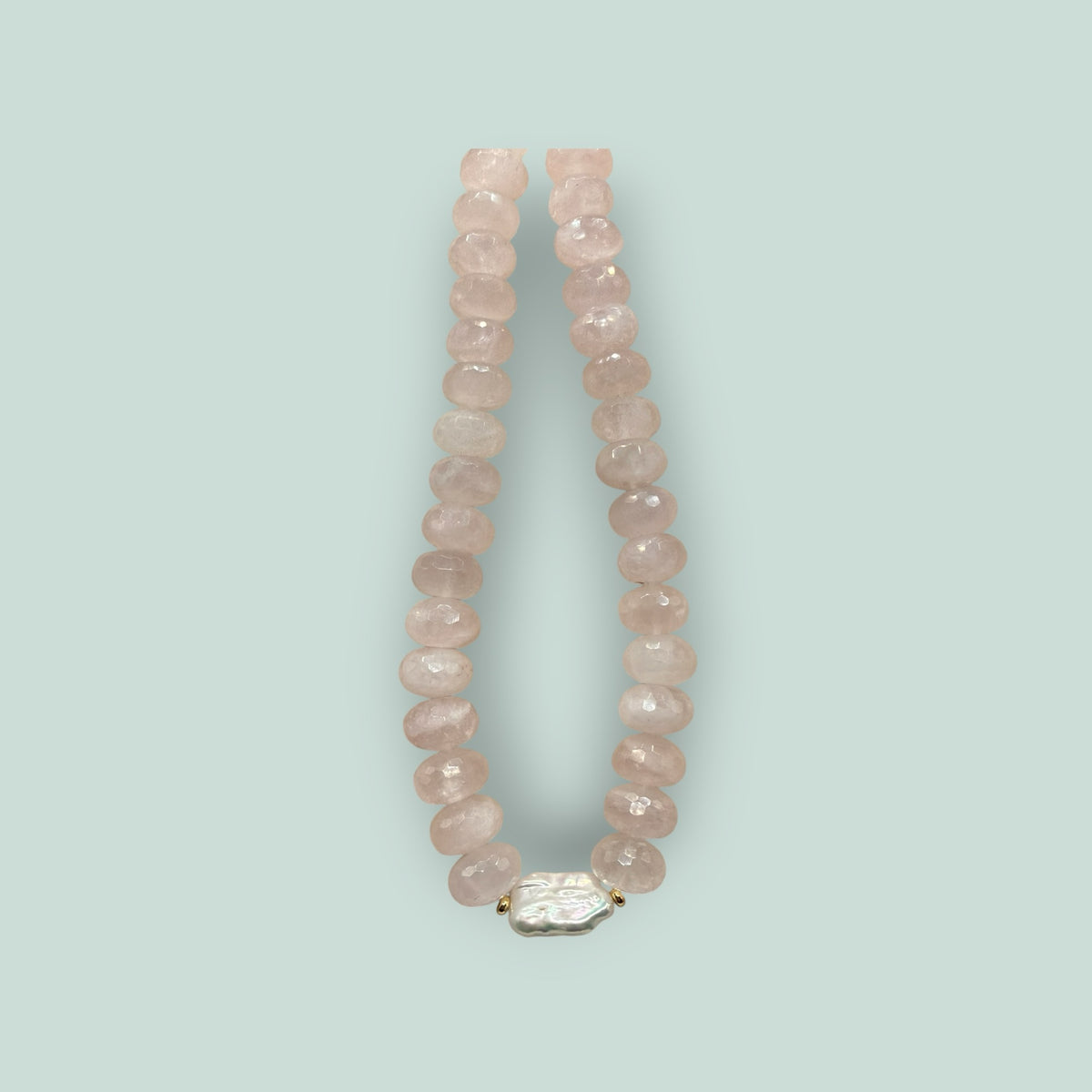 The Salty Bead Co handcrafted necklace with faceted rose quartz beads and a central organic baroque pearl accent.