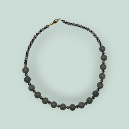 The Salty Bead Co handcrafted statement necklace featuring sage-green stone beads and black-and-white striped accents.