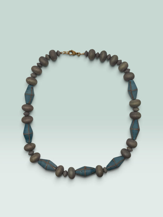The Salty Bead Co statement necklace featuring matte slate-grey rounded beads and diamond-shaped teal beads with wire accents.
