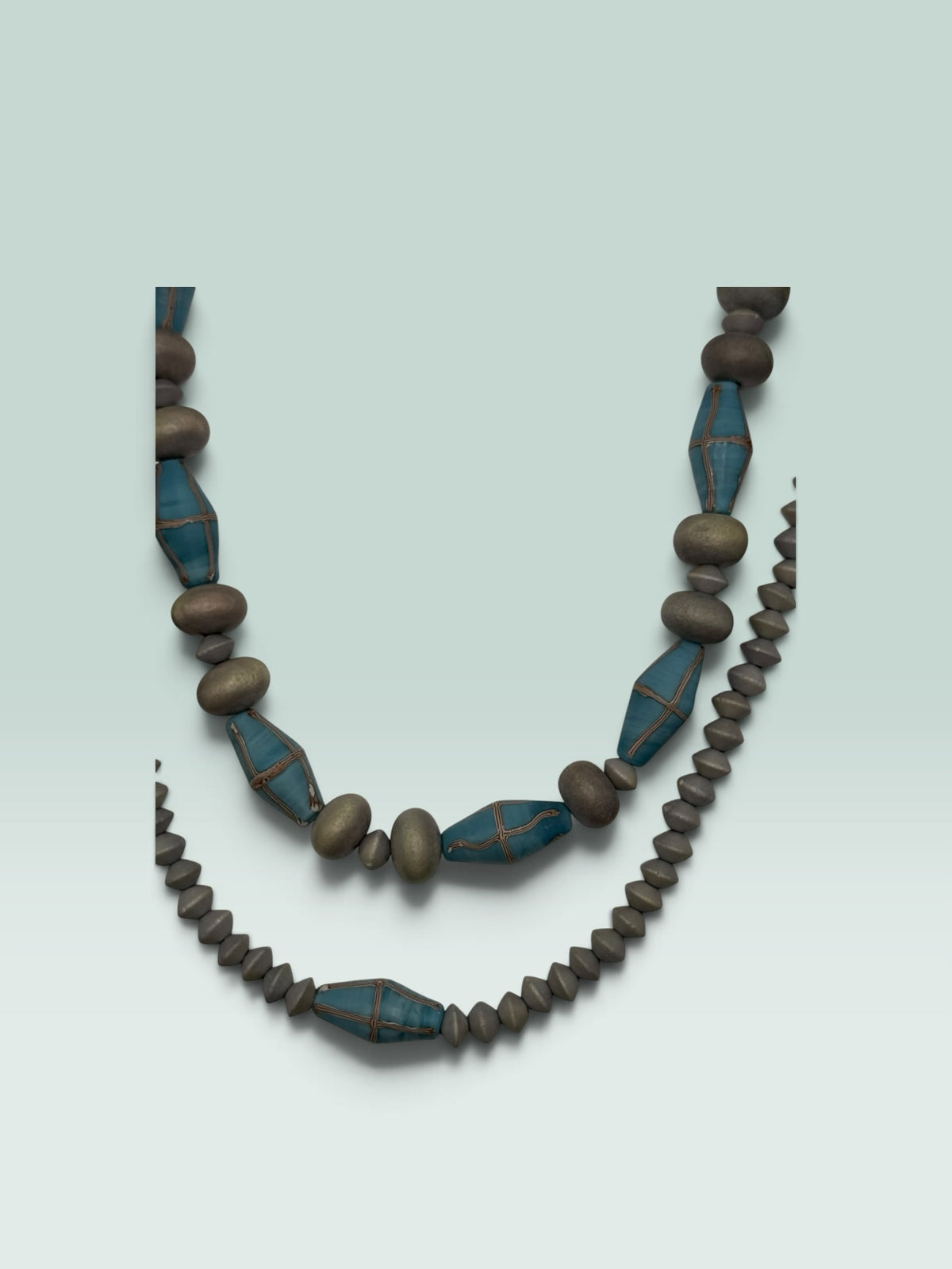 The Salty Bead Co statement necklace featuring slate-grey matte beads and diamond-shaped teal beads with wire accents.