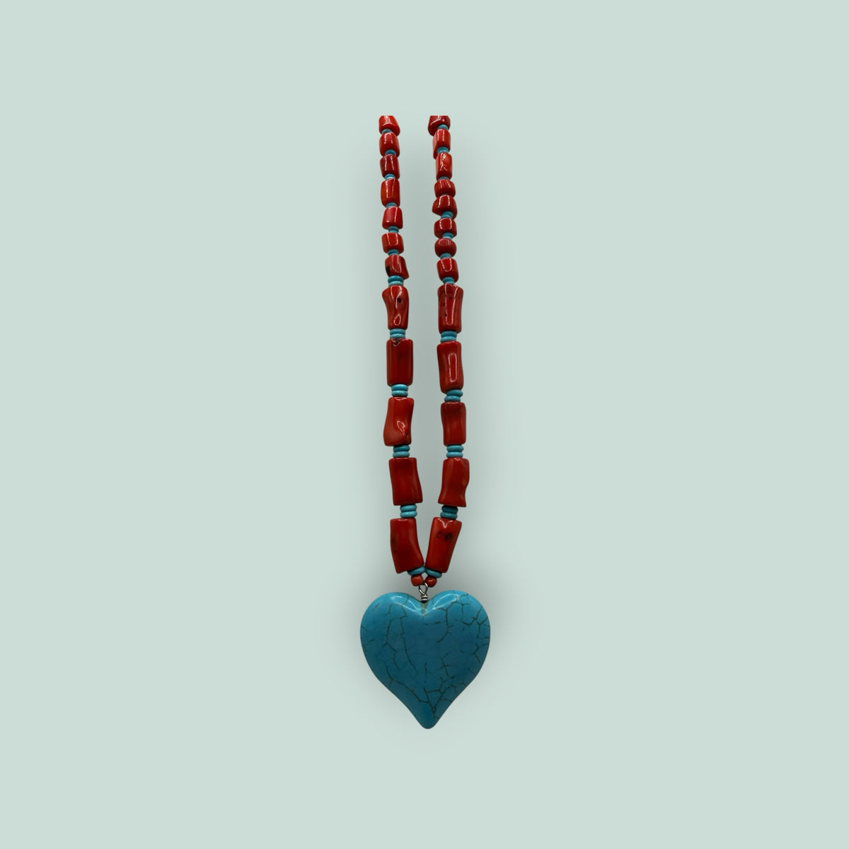 The Salty Bead Co artisan heart pendant necklace with red coral-style beads and a textured turquoise heart charm.