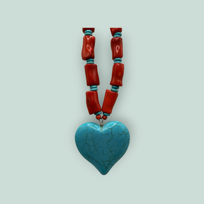 The Salty Bead Co artisan heart pendant necklace featuring a turquoise heart charm with red coral-style beaded strand.