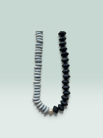 The Salty Bead Co two-tone statement necklace with slate-grey textured beads, matte black beads, and a central pearl.