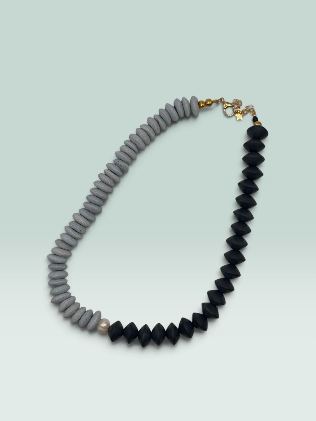 The Salty Bead Co two-tone statement necklace with slate-grey textured beads, matte black beads, and a freshwater pearl.